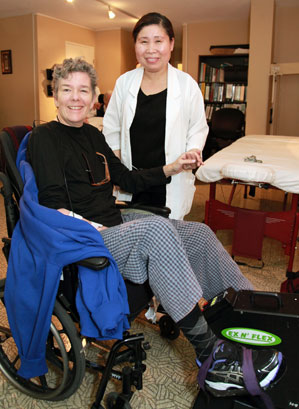 a nurse is standing next to a woman sitting in a wheelchair